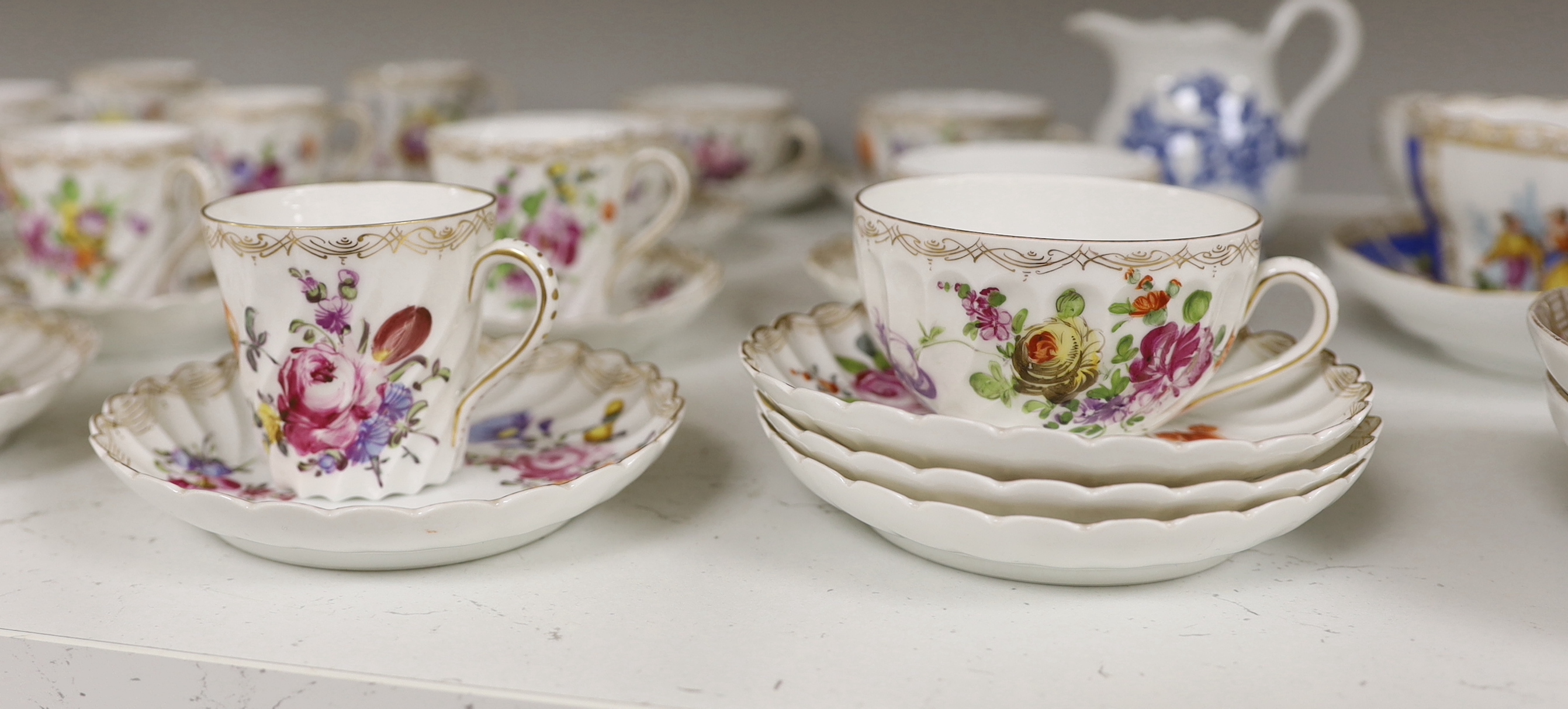 A group of porcelain Dresden tableware including cups and saucers and a blue and white jug